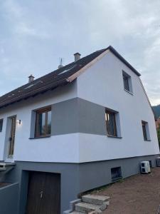 ein weißes Haus mit einer Tür und Fenstern in der Unterkunft Als AS DE COEUR La maison aux mille et un coeurs in Neuve-Église