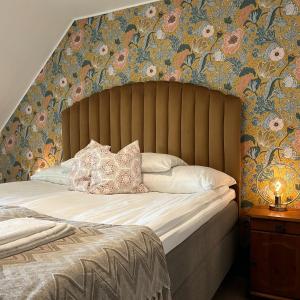 a bedroom with a large bed with floral wallpaper at Halmstad Gårdshotell in Halmstad