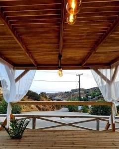 a porch with white curtains and a view of a road at KERAME PARADISE VILLA in Agios Kirykos