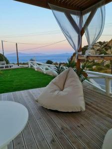 un oreiller assis sur une terrasse en bois avec un kiosque dans l'établissement KERAME PARADISE VILLA, à Agios Kirykos