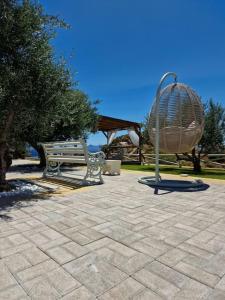un banc de parc assis à côté d'un grand objet métallique dans l'établissement KERAME PARADISE VILLA, à Agios Kirykos