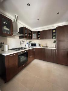 uma cozinha com armários de madeira e um forno com placa de fogão em EliteVista by Cristian em Timisoara
