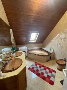 a bathroom with two sinks and a bath tub at House in Budapest
