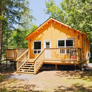 a large wooden cabin with a large deck at Parkway Cottage Resort and Trading Post in Dwight