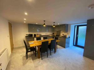 a kitchen and dining room with a wooden table and chairs at Langway in Gatebeck