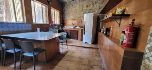 a kitchen with a bar with chairs and a refrigerator at Guattari House Santa Teresa in Rio de Janeiro