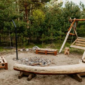 a playground with a fire pit and a swing at Głuszecki las in Skórcz