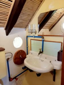 La salle de bains est pourvue d'un lavabo et d'un miroir. dans l'établissement Casa Belojardim E Antiga Fábrica de Manteiga, à Arco da Calheta