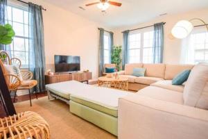 The Venice Oasis - 4BR-3BA 16 Guests في أتلانتيك سيتي: غرفة معيشة مع أريكة وتلفزيون