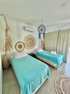 2 camas en una habitación con sábanas azules en La Reserve Villa Tropicana en Pipa