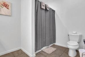 a bathroom with a toilet and a shower curtain at Bartram Dream House I - Bartram Beach Retreat in Atlantic City