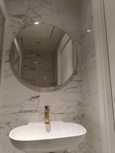 La salle de bains est pourvue d'un lavabo blanc et d'un miroir. dans l'établissement St Julian's Mercury Tower 13th floor Luxury Apt 1302 in Tallest Tower in Malta, à San Ġiljan