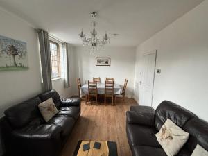un soggiorno con divano in pelle nera e tavolo di Large luxury apartment in the heart of Bakewell a Bakewell