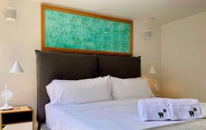 a bedroom with a bed with a large painting above it at Amazing 1BR with Terrace in Chico in Bogotá