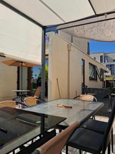 stół z krzesłami i parasol na patio w obiekcie VILLA THE SUN w mieście Concepción