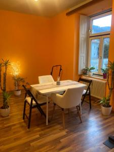 comedor con paredes de color naranja, mesa y sillas en VILLA BRUNEGG Leoben GÖSS, en Leoben