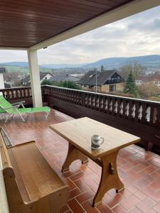 uma mesa de madeira na varanda com uma chávena de café em Wohngemeinschaft mit 3 privaten Zimmern, jedes Zimmer hat 2 Betten 