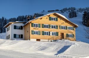 una casa en la cima de una ladera cubierta de nieve en Ferienhaus Erath, en Damüls