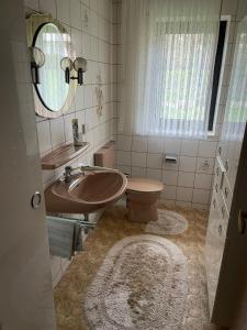 uma casa de banho com um lavatório, um WC e um espelho. em Wohngemeinschaft mit 3 privaten Zimmern, jedes Zimmer hat 2 Betten 