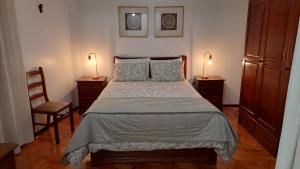 ein Schlafzimmer mit einem Bett mit zwei Lampen und einem Stuhl in der Unterkunft Judith House - Amadora Este in Amadora