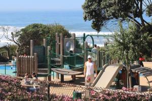 a boy on a slide at a playground at Adorable Octopus Hideaway: 2 min walk to the beach in Del Mar