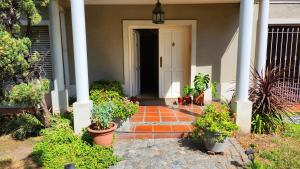 a front door of a house with potted plants at Alojamiento Aeropuerto in Ezeiza