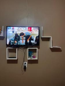 einen Flachbild-TV, der an einer Wand hängt in der Unterkunft Residência Shalom in Presidente Figueiredo