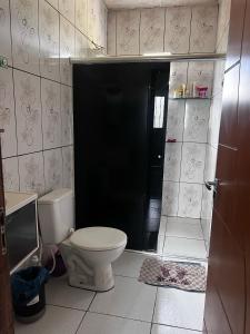 a bathroom with a toilet and a black door at Residência Shalom in Presidente Figueiredo