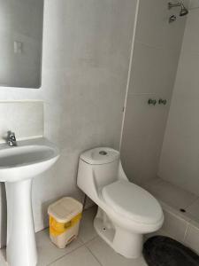 een witte badkamer met een toilet en een wastafel bij Casa de Campo Paz y Bien - Cieneguilla in Cieneguilla