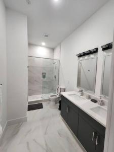 La salle de bains blanche est pourvue d'un lavabo et de toilettes. dans l'établissement Close to NYC - 2Bed Vast Stylish Apt, à Bayonne