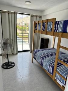 een slaapkamer met 2 stapelbedden en een balkon bij Casa de Campo Paz y Bien - Cieneguilla in Cieneguilla