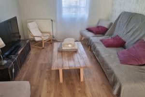 a living room with a couch and a coffee table at Belle Maison proche base nautique olympique et Disney in Torcy