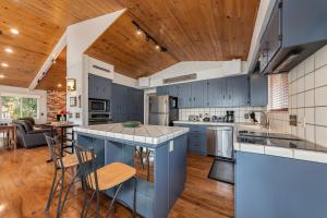 Il comprend une cuisine avec des placards bleus et un plafond en bois. dans l'établissement Forest Psalm Previously Martin Ridge, à Arnold