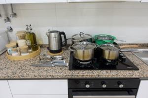 a stove with pots and pans on top of it at Alvalade CoLiving Hub in Lisbon