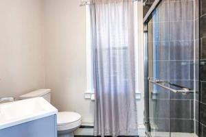 een badkamer met een douche, een toilet en een wastafel bij Luxe Bartram Beach Retreat 4BD - 3BA in Atlantic City