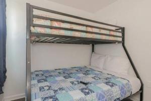 a metal bunk bed with a quilt on it at Arcade Nook & New Sea Turtle Mural- 3BR in Atlantic City