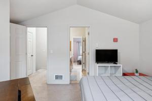 a white bedroom with a bed and a television at 2BR Seattle Oasis - A Short Stroll to Light Rail in Seattle