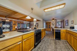a large kitchen with wooden cabinets and black appliances at Dragonfly Lodge in Arnold
