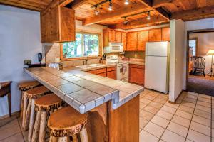 eine Küche mit einer Theke mit Hockern und einem Kühlschrank in der Unterkunft Hugging Trees in Arnold