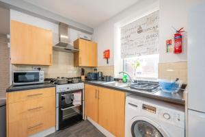 a kitchen with a washing machine and a washer at *RA9GH* For your most relaxed & Cosy stay + Free Parking + Free Fast WiFi * in Bramley