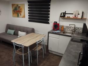 uma pequena cozinha com uma mesa e um sofá em Le Ptit Lou em Kaysersberg