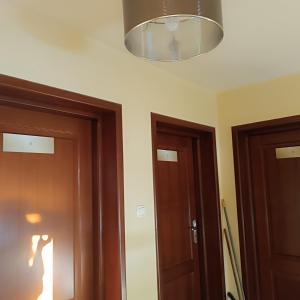 Pokój z dwoma drzwiami i urządzeniem oświetleniowym w obiekcie Noclegi w Bilczy 5 km do Kielc w mieście Bilcza
