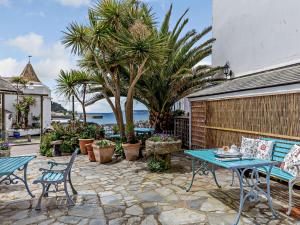 a patio with tables and chairs and palm trees at 2 Bed in Marazion 82154 in Marazion