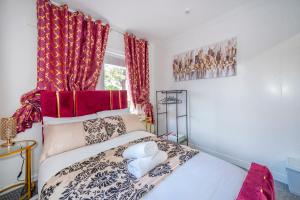 a bedroom with a white bed with red curtains at *RA9GH* For your most relaxed & Cosy stay + Free Parking + Free Fast WiFi * in Bramley