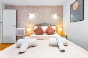 una camera da letto con un grande letto bianco con cuscini di Modern One Bedroom Flat - Near Heathrow, Windsor Castle, Thorpe Park - Staines London TW18 a Staines upon Thames