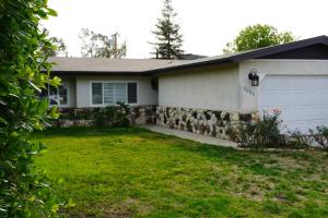 a house with a stone wall and a garage at Cozy Family Hideaway, sleeps 8, 4 tv's yard, shops in Simi Valley