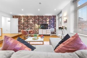uma sala de estar com um sofá e uma mesa em Modern One Bedroom Flat - Near Heathrow, Windsor Castle, Thorpe Park - Staines London TW18 em Staines upon Thames