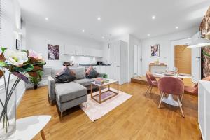 ein Wohnzimmer mit einem Sofa und einem Tisch in der Unterkunft Modern One Bedroom Flat - Near Heathrow, Windsor Castle, Thorpe Park - Staines London TW18 in Staines upon Thames