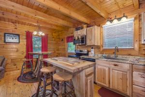 uma cozinha com uma ilha central numa cabana de madeira em Hook, Line and Sinker Cabin features firepit and hot tub! em Sevierville