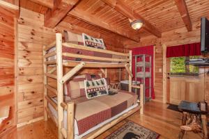 um quarto com 2 beliches num chalé de madeira em Hook, Line and Sinker Cabin features firepit and hot tub! em Sevierville